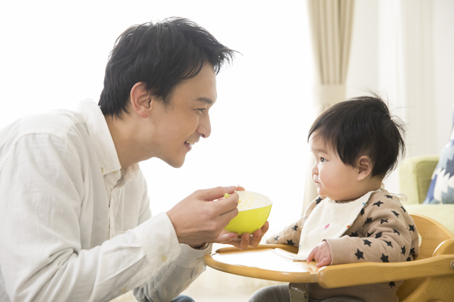 赤ちゃんにご飯をあげるパパ