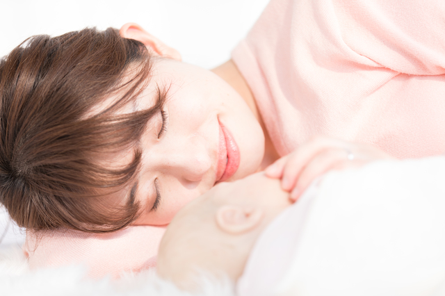 赤ちゃんと一緒に眠るママ